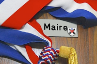 Photo d'une écharpe de maire avec un panneau "Maire" et le blason de Waldighoffen