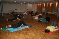Photo d'un cours de yoga montrant les participantes en pleine relaxation.