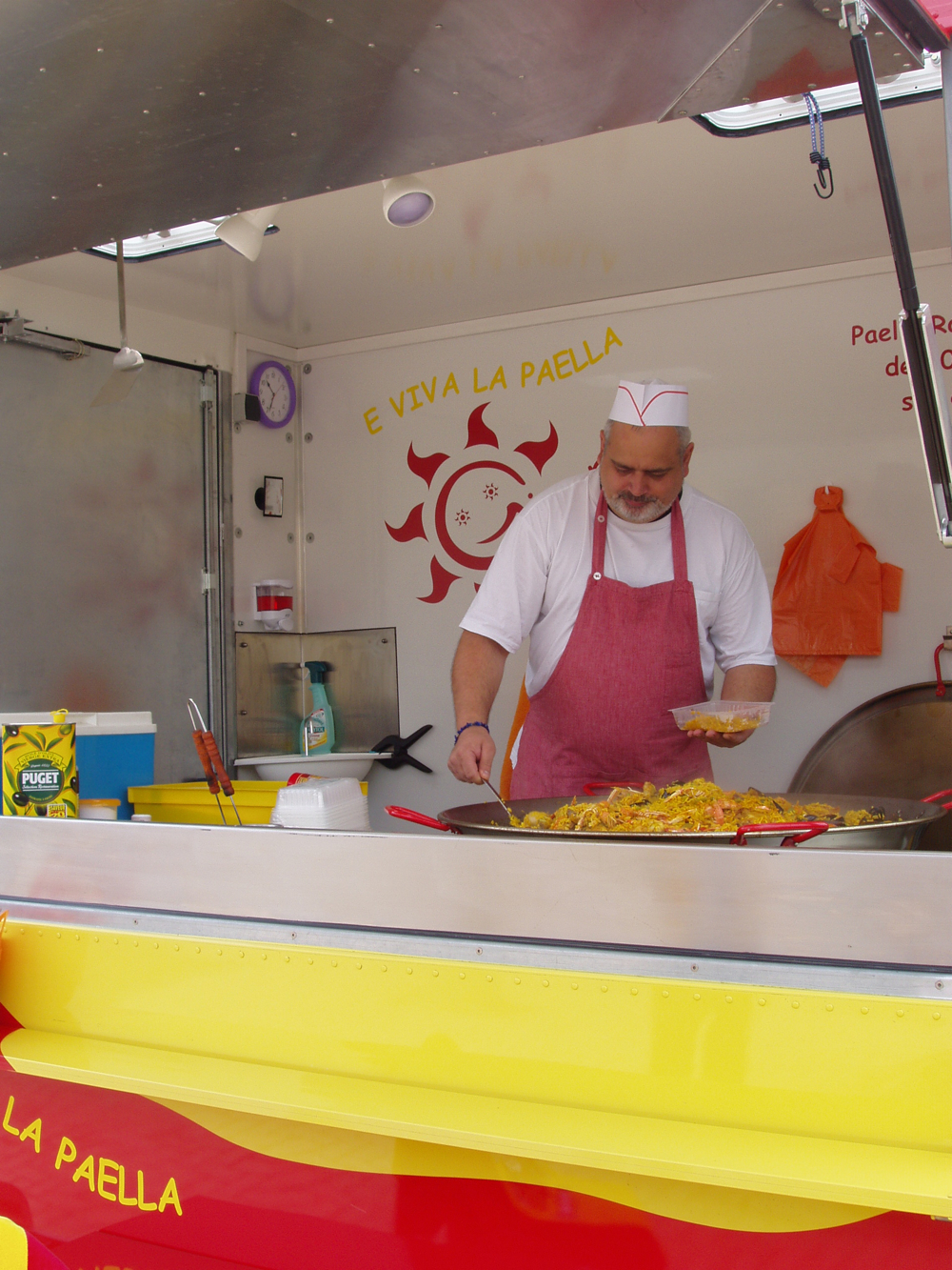 M. Girard remplissant une barquette dans son camion E Viva La Paella