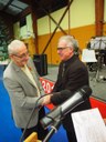 M; Reinhard sert la main de M. Dugardin pour le féliciter pour sa médaille départementale du bénévolat. Poignée de main